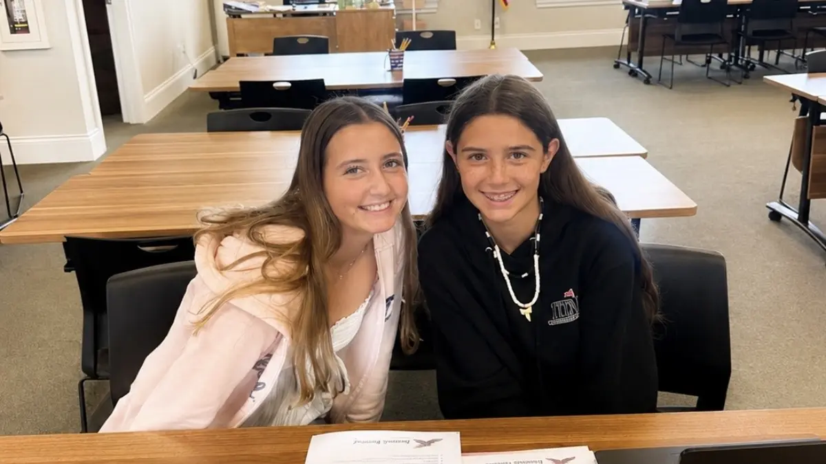Two Freedom Ave Maria students smiling at their desk