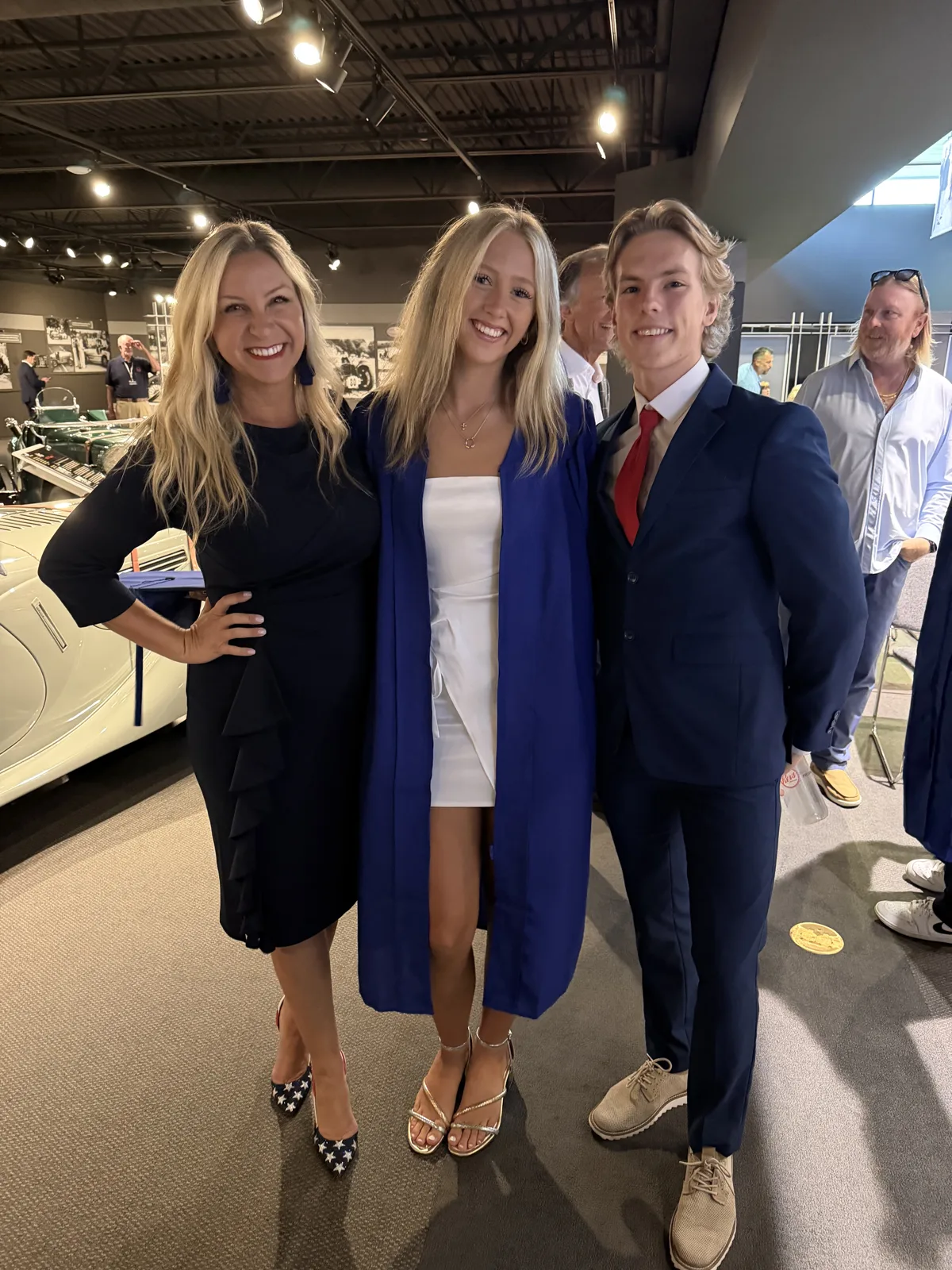 A Freedom graduate in cap and gown with family at Revs Institute