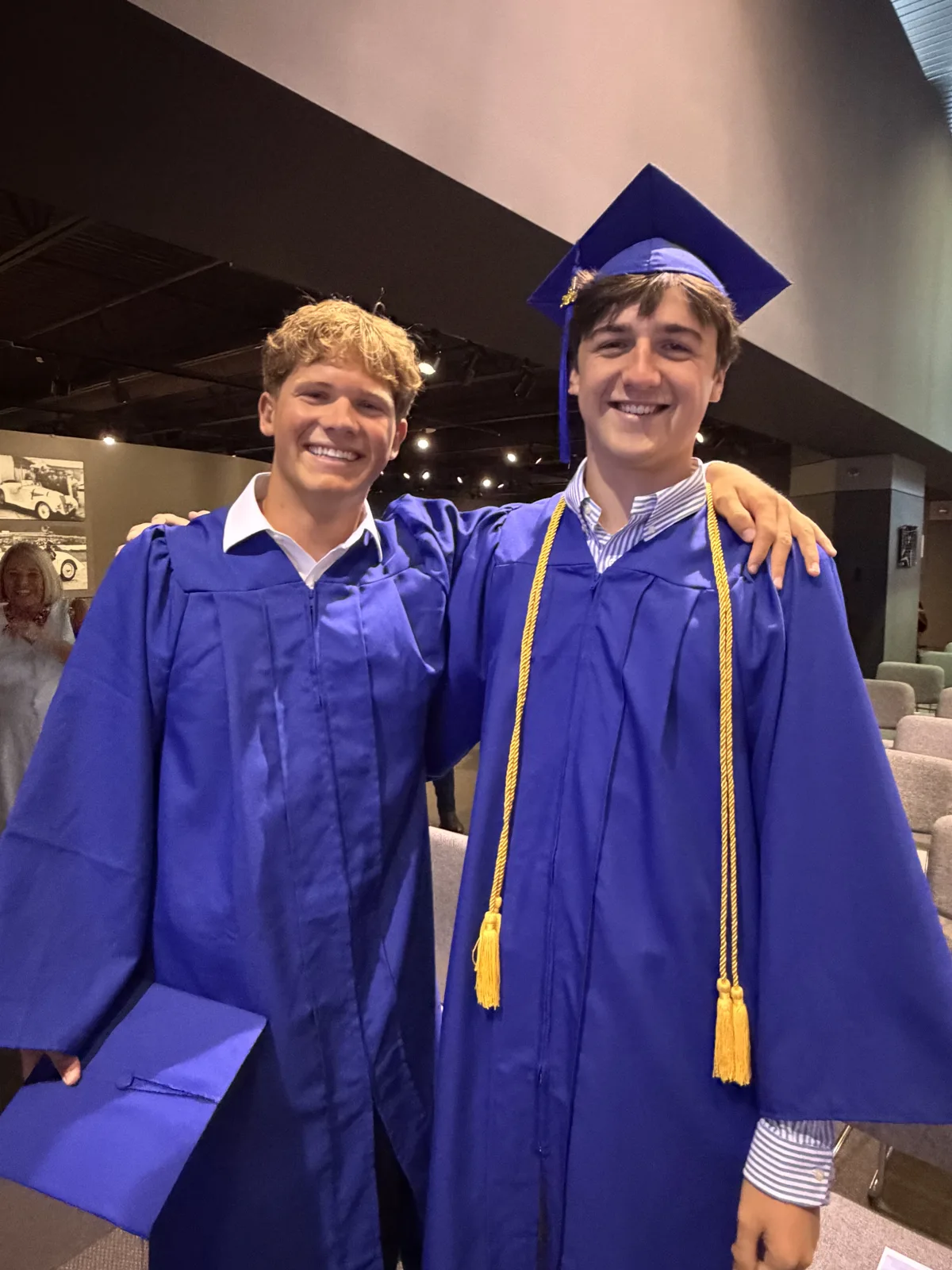 Two Freedom graduates smiling in caps and gowns