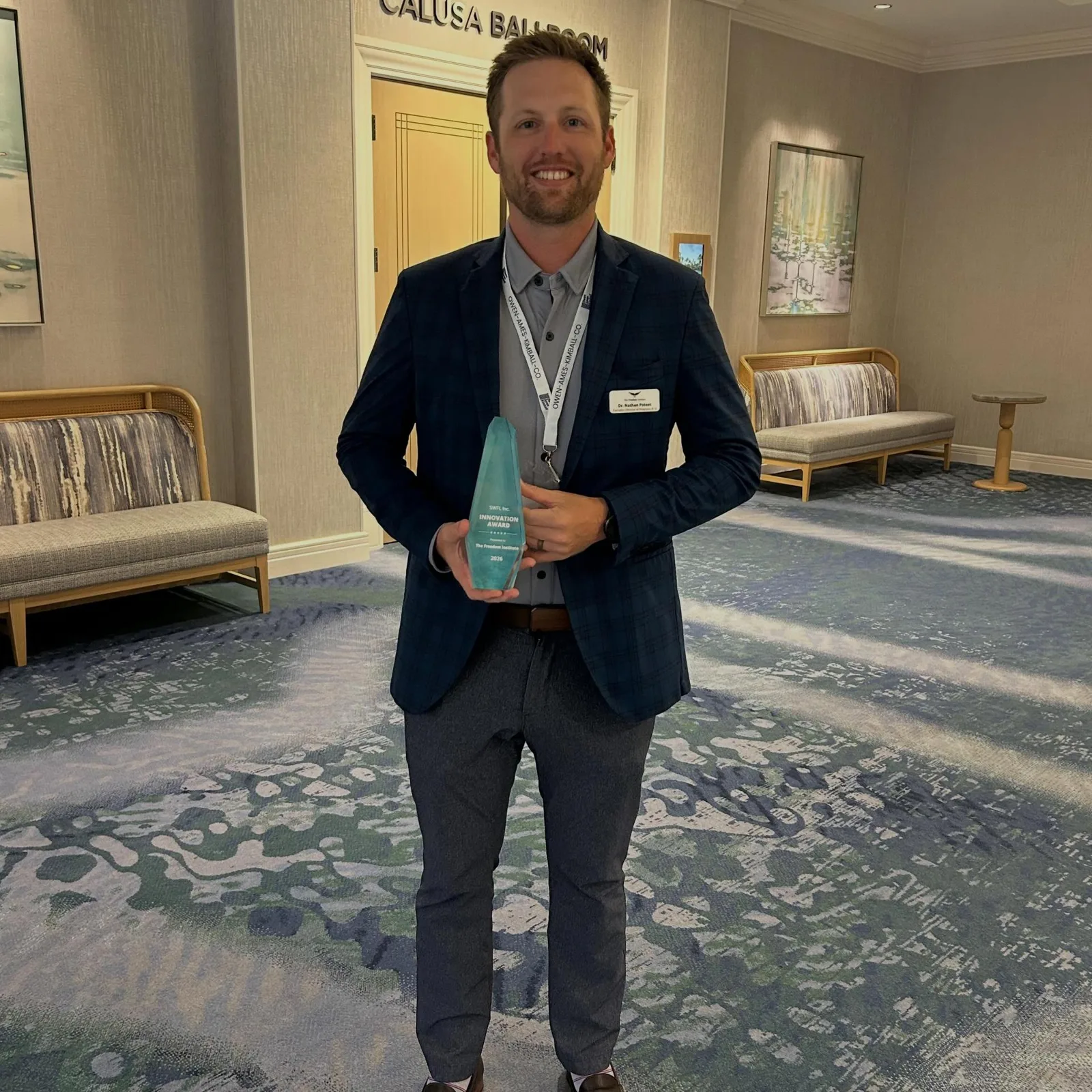 Nathan Poteet holding the SWFL Inc. Innovation Award