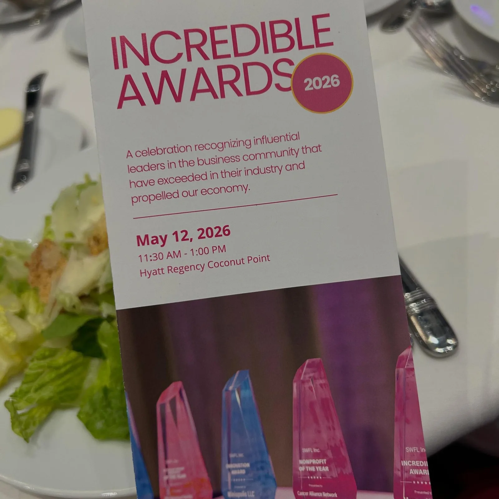 The 2026 INCredible Awards program on a table beside the award trophies