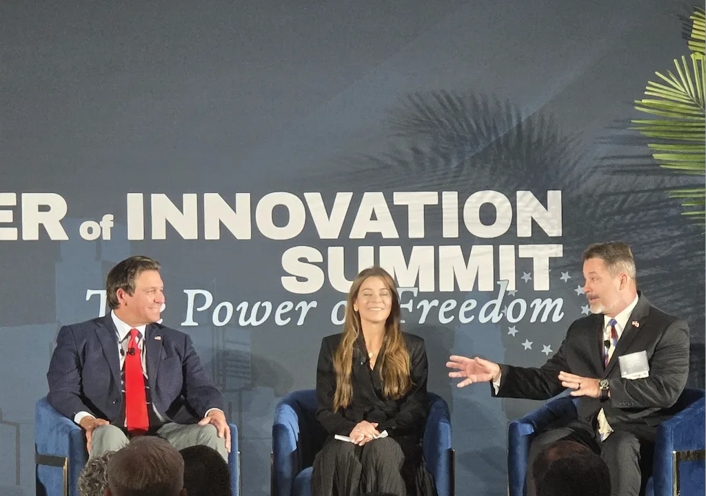 Governor Ron DeSantis, Maggie Fresen and Christopher Marker on stage at the Power of Innovation Summit